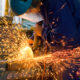 Men at work grinding steel
