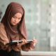 A woman openly wears a hijab while working on a tablet as her workplace has guidelines to help accomodate her religious beliefs