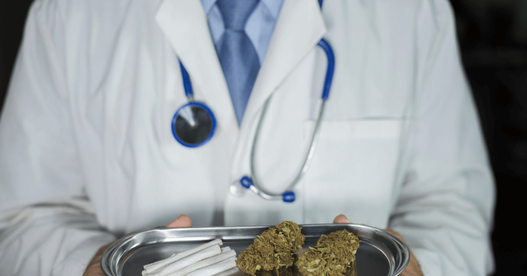 A physician presents a tray with medical marijuana in both kush and rolled form to their patient.