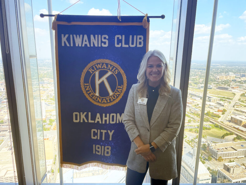 woman stands next to a banner in an office building