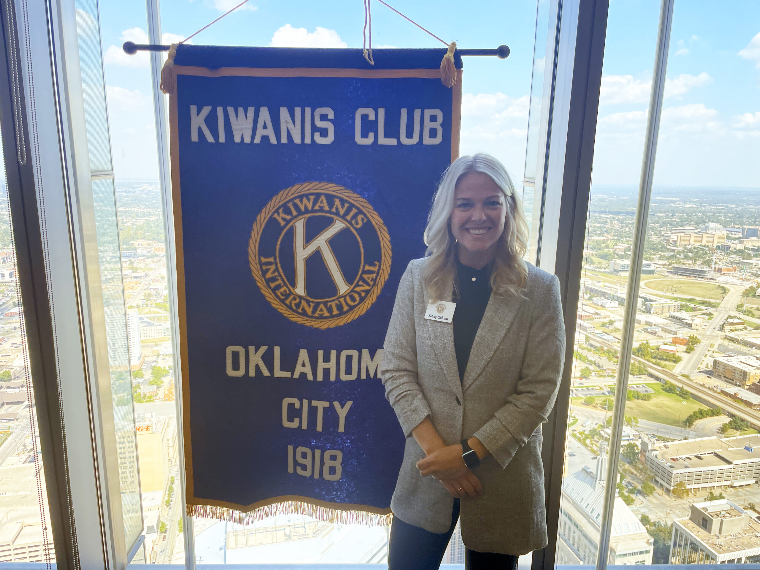 woman stands next to a banner in an office building
