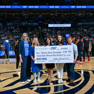 Phillips Murrah attorneys present check to OKC Thunder at halfcourt prior to final 2023-2024 home game. 