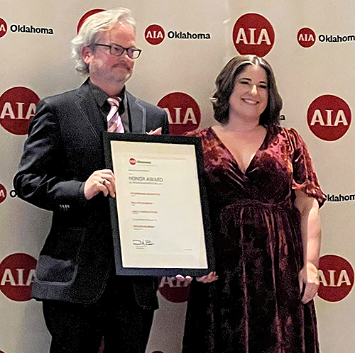 Brian Fitzsimmons and Kristin Fasking standing on stage with Honor Award at the AIA Oklahoma Design Excellence Awards.