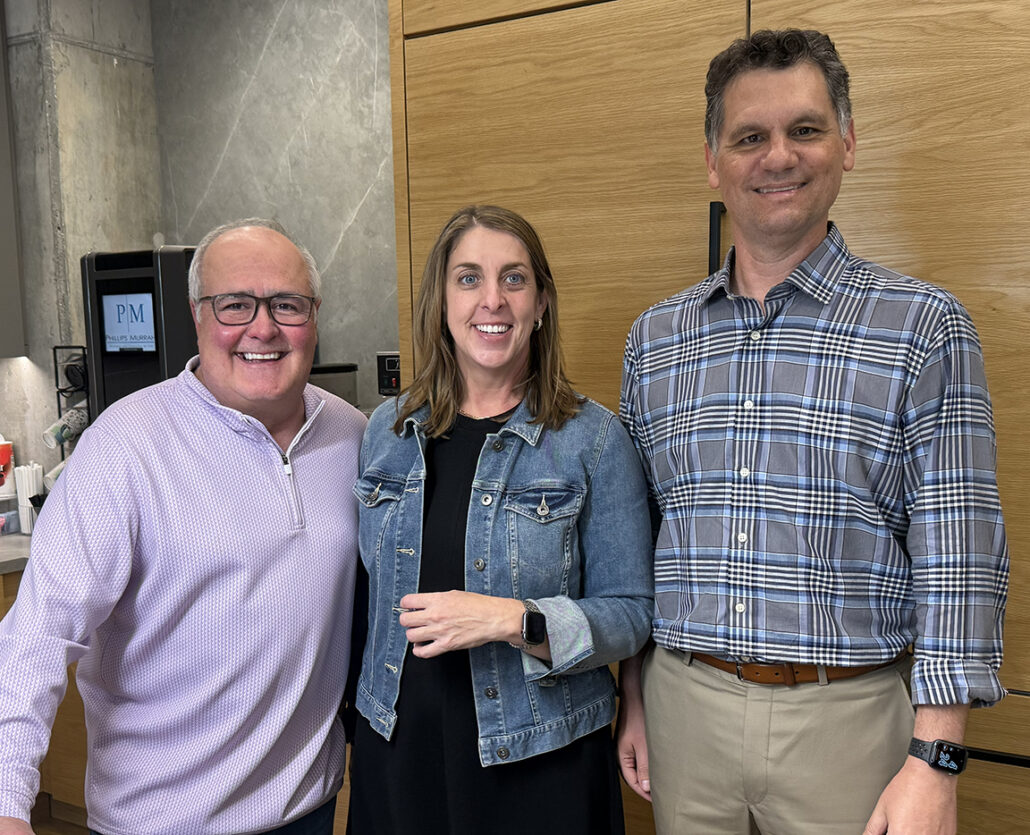two male attorneys and one female attorney standing together posing for a picture.